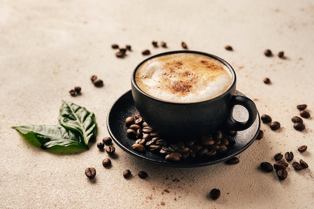 Cup of cappuccino green coffee leaves and beans on light background Close up