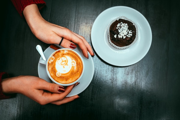 Cup of cappuccino in hands