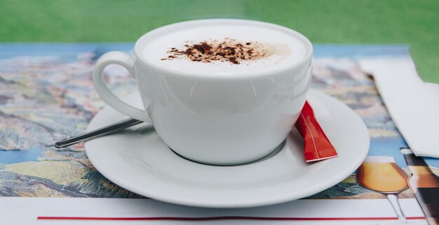 Foto tazza di cappuccino sul tavolo. cappuccino caldo in tazza bianca giaceva sul tavolo di legno. momento di relax.