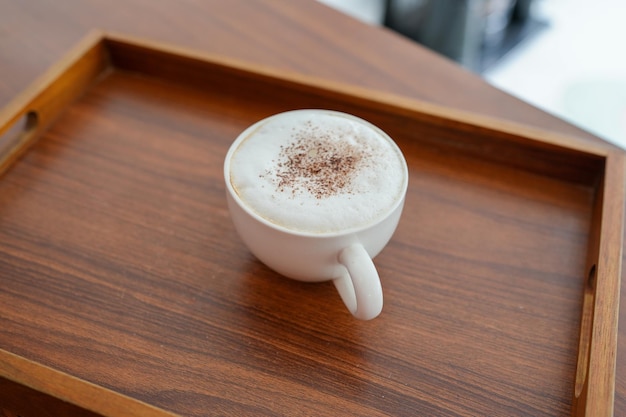 Cup cappuccino on wooden tray