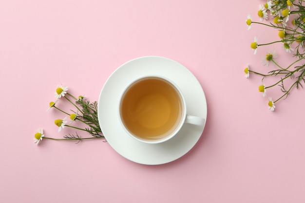 Cup of chamomile tea on pink