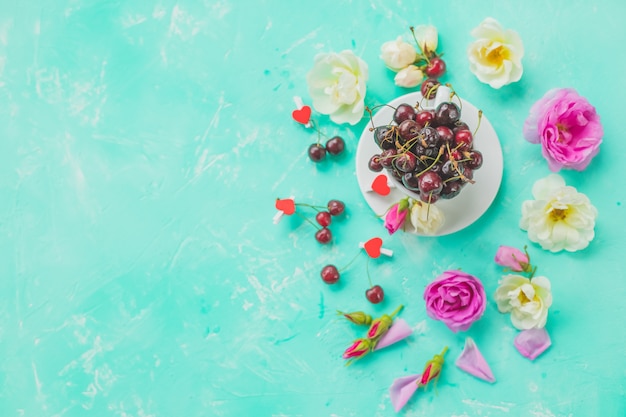 Cup of cherry berries, rose tea with bunch branch Roses 