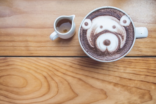 Cup of chocolate art on the wooden table in the coffee shop