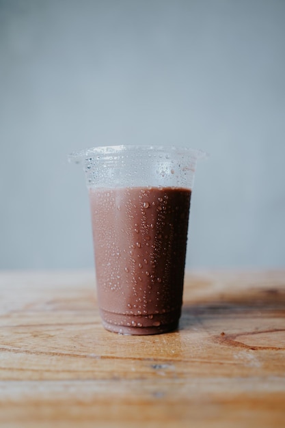 A cup of chocolate smoothie with a blue background