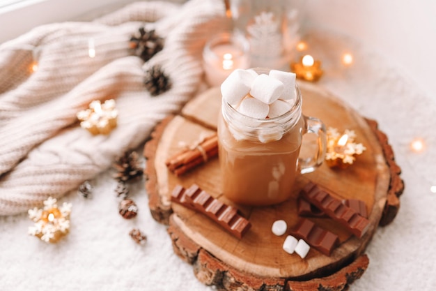 A cup of cocoa with marshmallows in a cozy homely atmosphere on the windowsill Christmas aesthetics