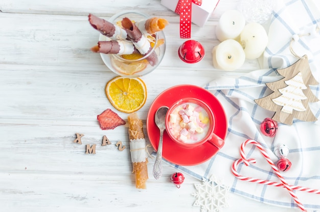 Cup of cocoa with marshmallows with fruit pastille and chips