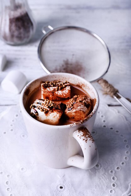 Cup of cocoa with marshmallows on wooden background