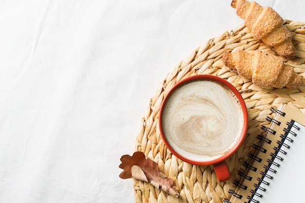 Cup of coffe and pastry on white background, autumn mood