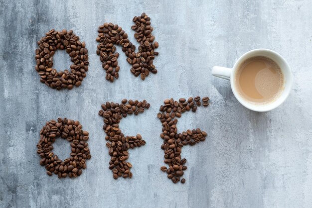 cup of coffee as a switch between ON and OFF beans gray stone background