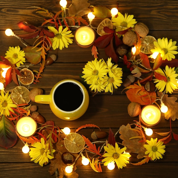 cup of coffee on the autumn background with leaves and flowers