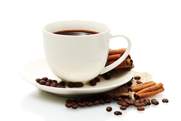 Cup of coffee beans and cinnamon sticks isolated on white