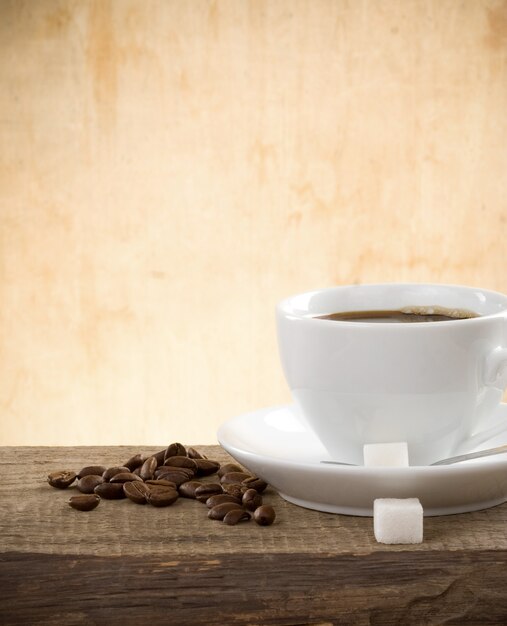 Tazza di caffè e fagioli su legno