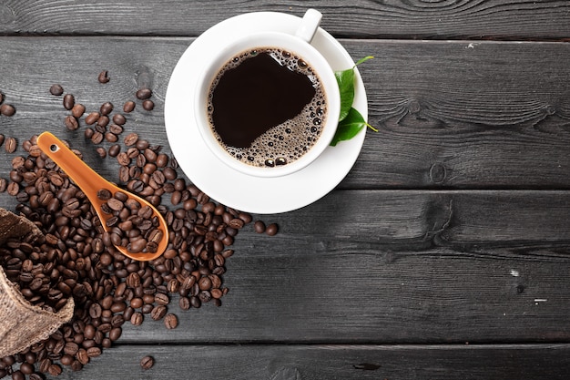 Cup of coffee and beans on wooden