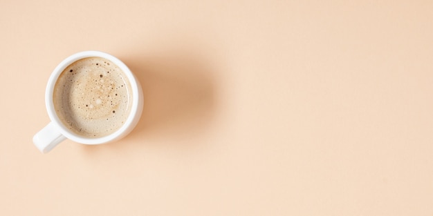 Cup of coffee on beige background