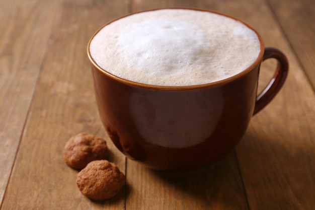 Cup of coffee and biscuits on wooden background