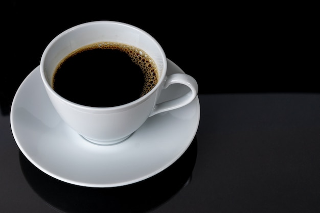 Cup of coffee over black background.