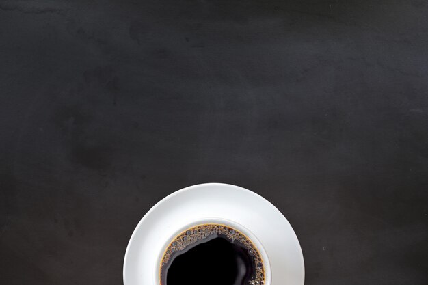 Cup of coffee on black surface