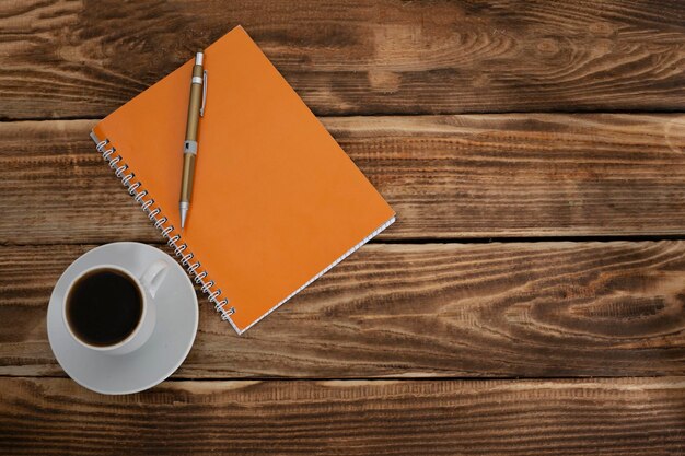 cup coffee and blank notepad on wooden table