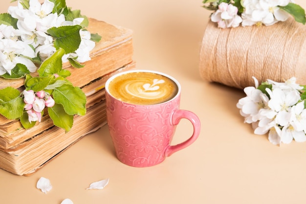 Чашка кофе и цветущие яблочные веточки с винтажными книгами Весенний натюрморт