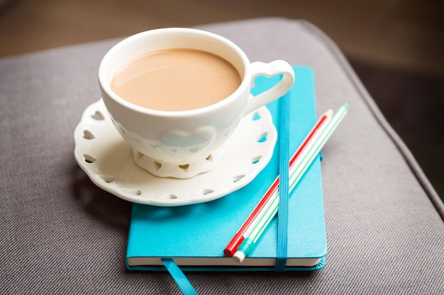 Cup of coffee and blue notebook