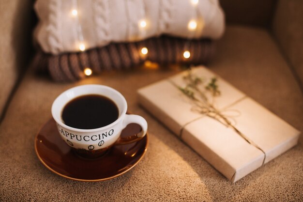 一杯のコーヒーと格子縞の読書と家庭のリラクゼーションの概念に関する本
