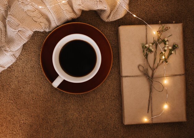 a cup of coffee and a book on a plaid reading and home relaxation concept
