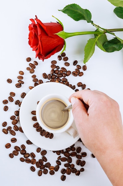 Cup of coffee and a bouquet of red roses.