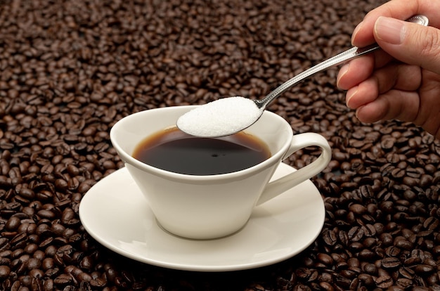 Foto tazza di caffè sui chicchi di caffè marroni