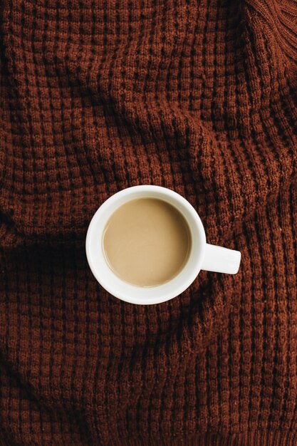 Cup of coffee on brown plaid