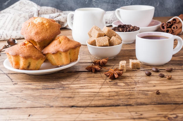 Cup of coffee, brown sugar and cinnamon with anise on wood