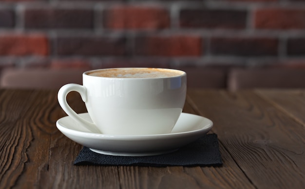 茶色の木製のテーブルの上のコーヒーカップ