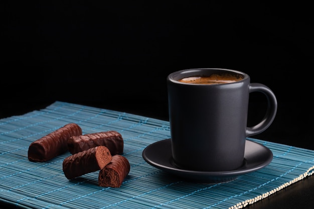 Foto tazza di caffè e cioccolatini sulla stuoia di bambù