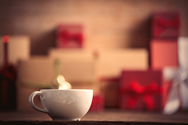 Cup of coffee and Christmas gifts on background