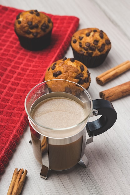 Cup of coffee, cinnamon and muffins