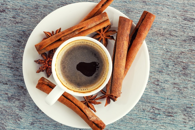 A cup of coffee, cinnamon sticks and anise stars 