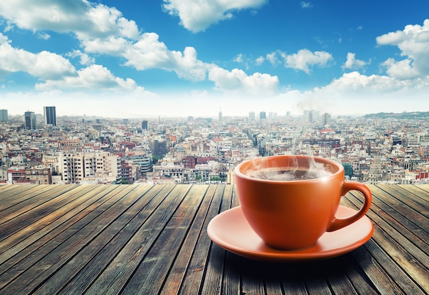 Cup of coffee on city background