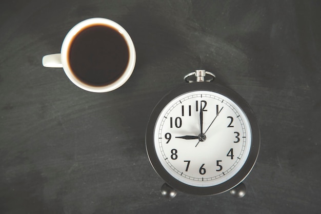Photo cup of coffee and clock