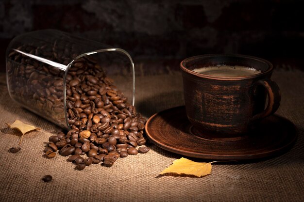 Cup of coffee and coffee beans on the table in the kitchen