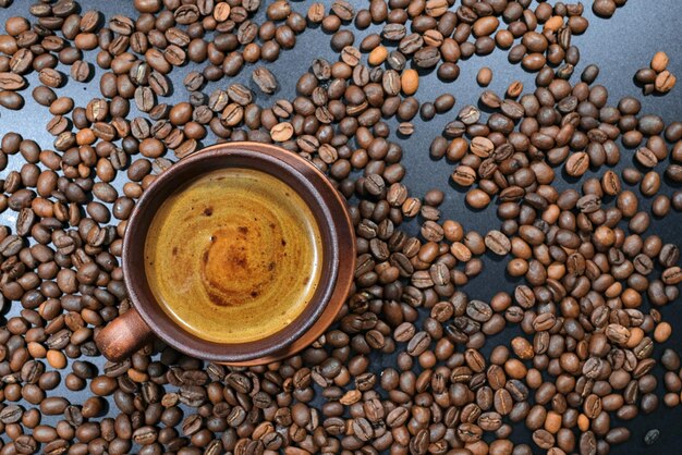 A cup of coffee on coffee beans on the table Top view