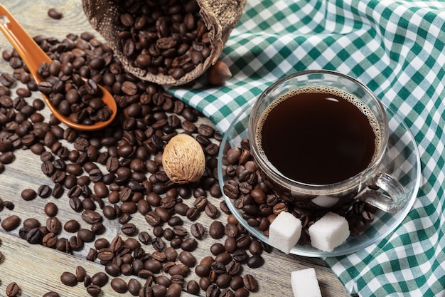 一杯のコーヒーとテーブルの上のコーヒー豆。