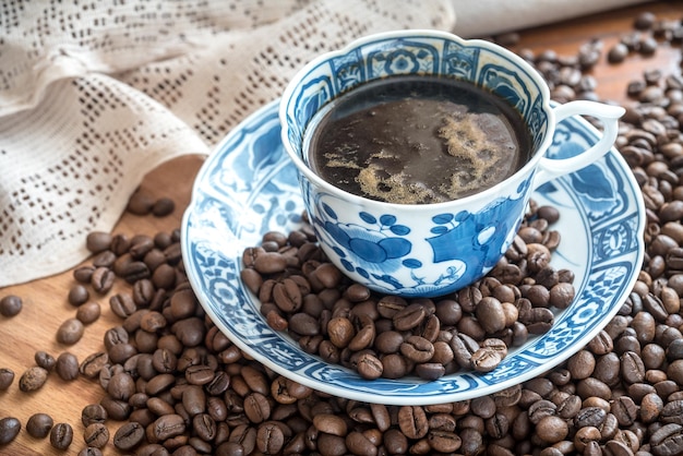 A cup of coffee and coffee beans on the table