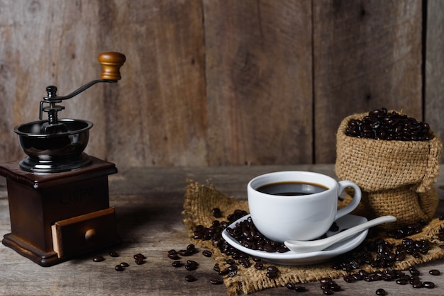 Cup of coffee and coffee beans on table