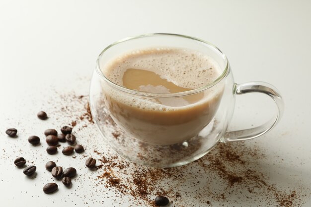 Cup of coffee and coffee beans on white