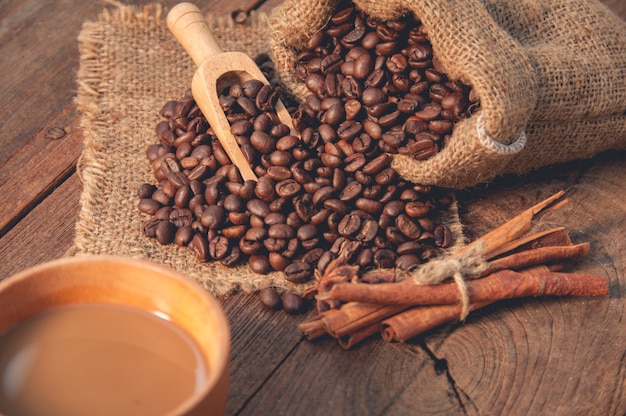 Tazza di caffè e chicchi di caffè sul tavolo di legno.