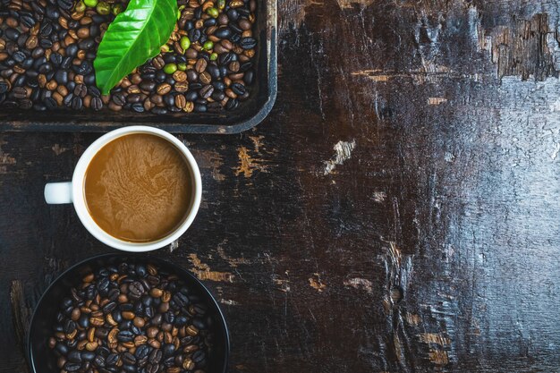 A cup of coffee and coffee beans on a wooden table