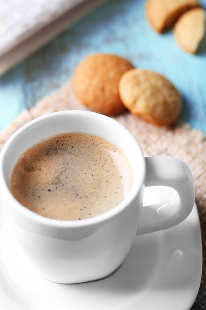 Cup of coffee on color wooden background