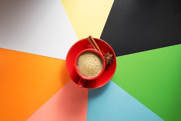 Cup of coffee at colorful paper surface