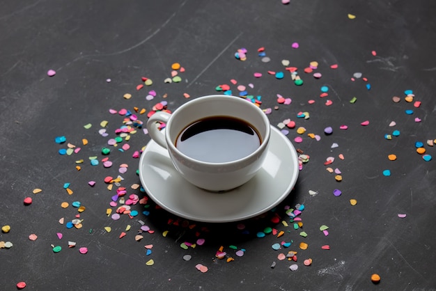 Cup of coffee and confetti on a table