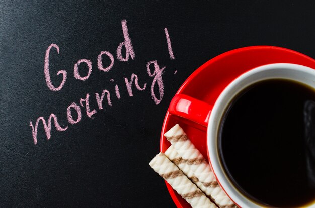 Photo cup of coffee and cookie on a dark background.