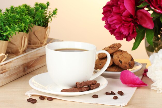 Foto una tazza di biscotti al caffè, cioccolato e fiori sul tavolo del caffè